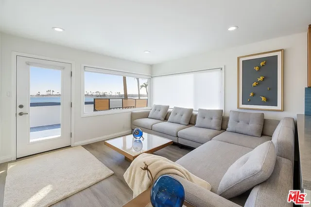 a living room with furniture and view of kitchen