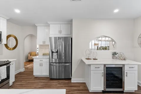 a kitchen with stainless steel appliances granite countertop a refrigerator a stove a sink and a wooden floors