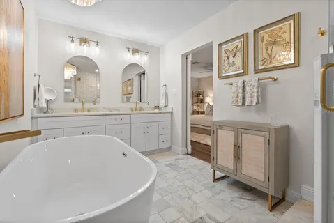 a spacious bathroom with a tub sink and mirror