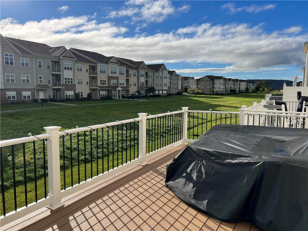 2356 Raya Way Easton, PA 18045 - Photo 25 of 28 An elevated wood deck overlooks a sprawling green common area under a blue sky.