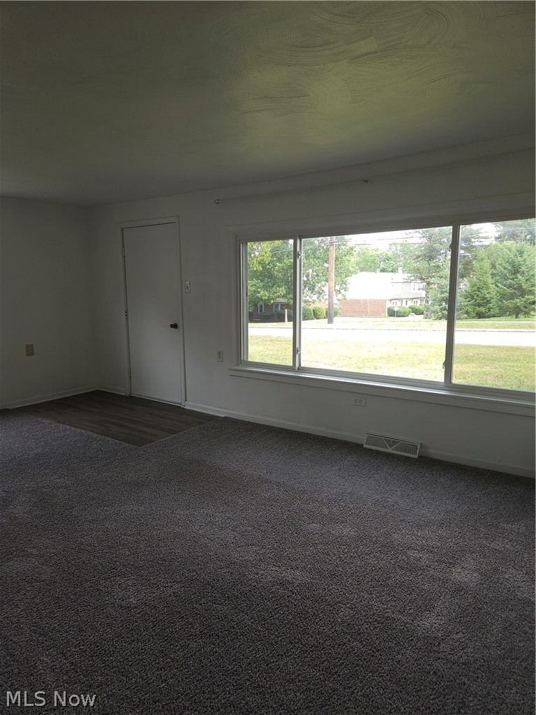 4660 Darrow Road Stow, OH 44224 - Photo 4 of 25 Bright, open interior space featuring expansive sliding glass doors with natural light, neutral carpet flooring, and white wall finishes