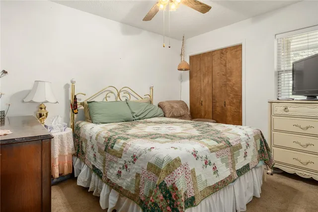 a bedroom with a bed and a flat tv screen on dresser
