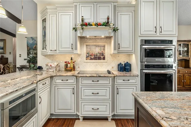 a kitchen with granite countertop a stove oven and sink
