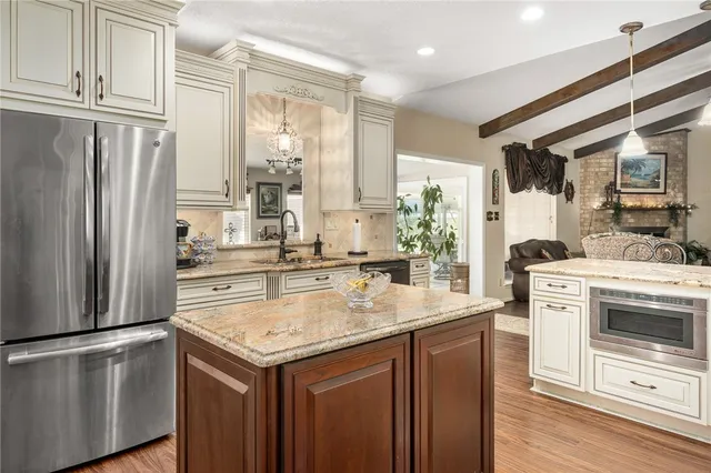 a kitchen with stainless steel appliances granite countertop a sink and a refrigerator