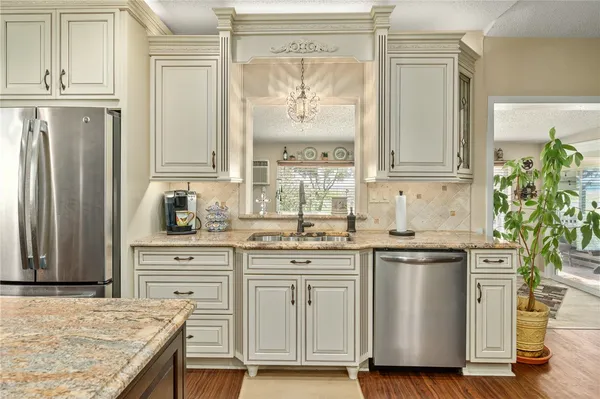a kitchen with granite countertop a sink stainless steel appliances and cabinets