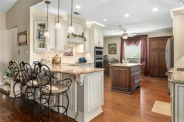 a kitchen with stainless steel appliances kitchen island granite countertop a stove a sink and a refrigerator
