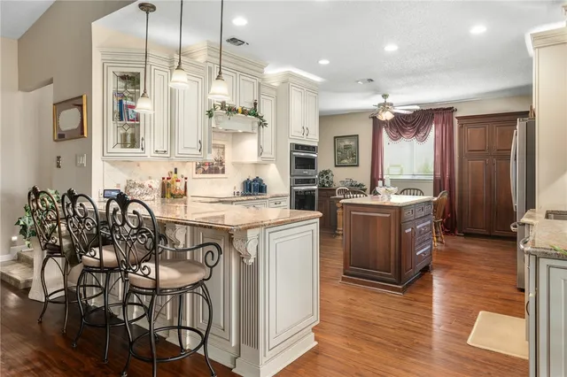 a kitchen with stainless steel appliances kitchen island granite countertop a stove a sink and a refrigerator