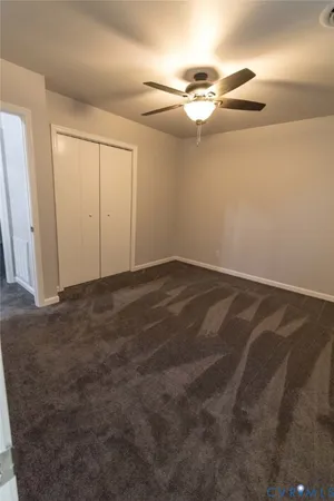 a view of a room with a ceiling fan and closet