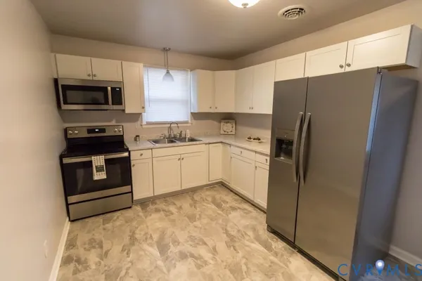 a kitchen with a refrigerator sink and microwave