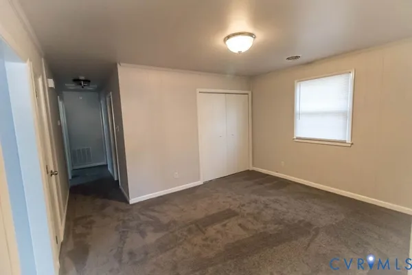 an empty room with windows and closet