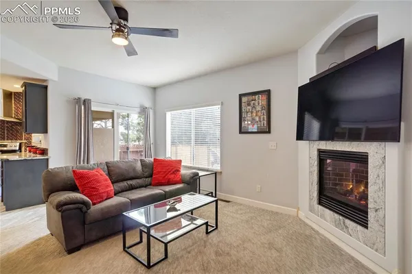 a living room with furniture a flat screen tv and a fireplace