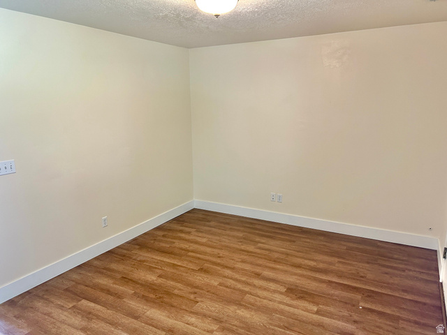 334 West Rodeo Lane South Logan, UT 84321 - Photo 4 of 12 Room featuring wood-finish flooring, light-toned wall paint, white baseboards, and a ceiling-mounted light fixture