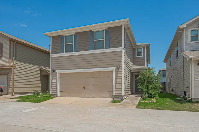 a front view of a house with a yard and a garage