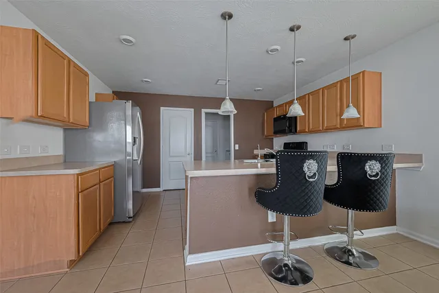 a kitchen with stainless steel appliances granite countertop a refrigerator a sink and white cabinets