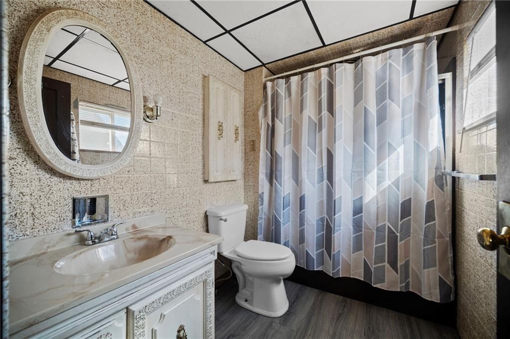 1412 Broadway Avenue McKees Rocks, PA 15136 - Photo 12 of 39 a bathroom with a granite countertop sink a toilet and a mirror