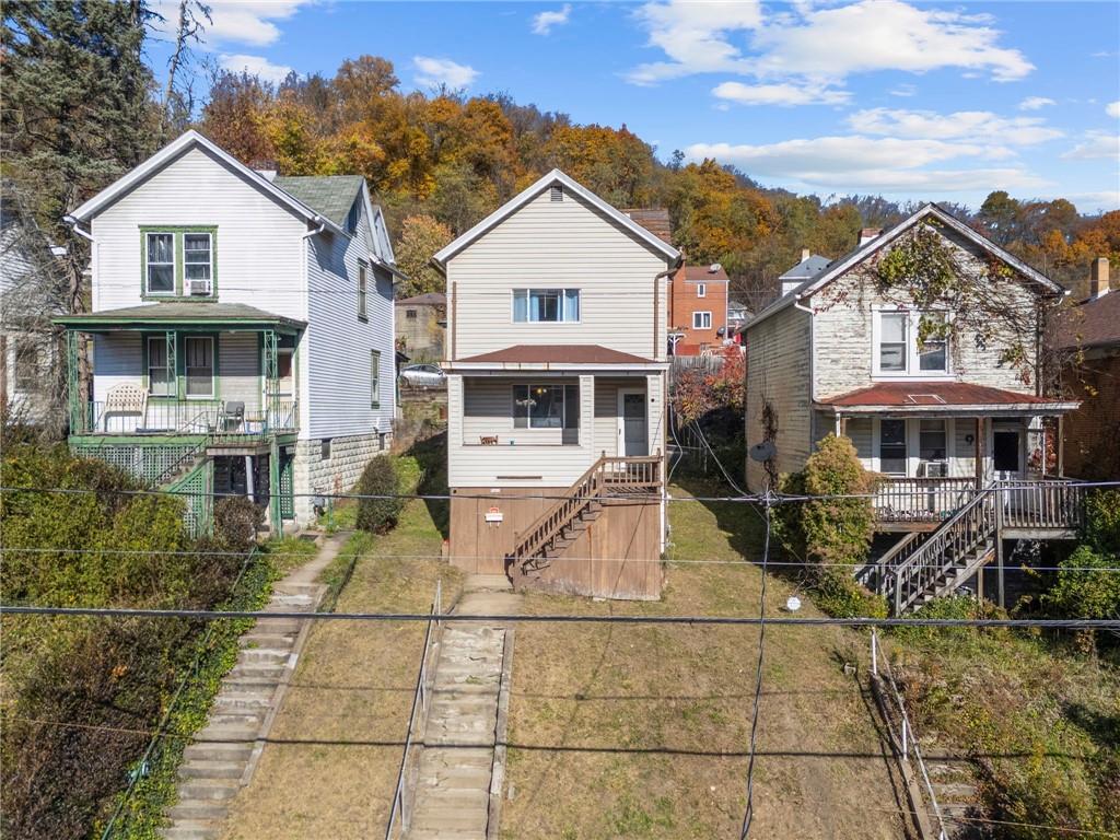 1412 Broadway Avenue McKees Rocks, PA 15136 - Photo 30 of 39 a view of a white house with large windows and a small yard