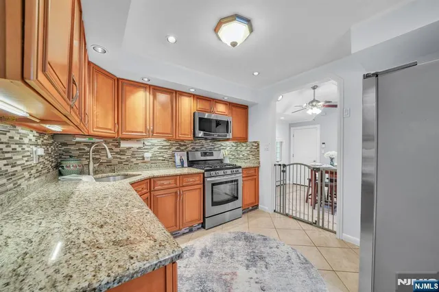 a kitchen with stainless steel appliances granite countertop a sink stove and cabinets