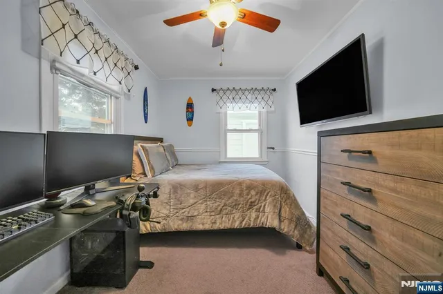 a bedroom with a bed and a flat tv screen on the dresser