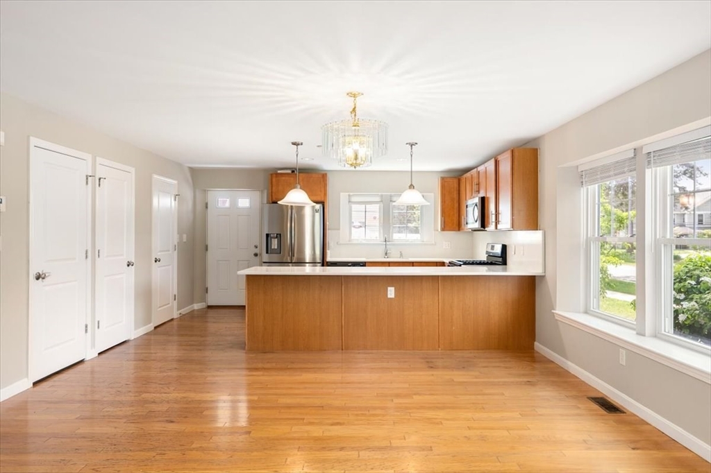 6 Bates Street, Unit A Devens, MA 01434 - Photo 13 of 41 a large kitchen with kitchen island a large window a sink and cabinets
