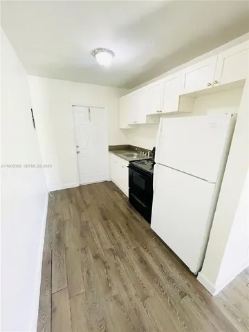 a kitchen with a refrigerator a stove top oven and a dishwasher