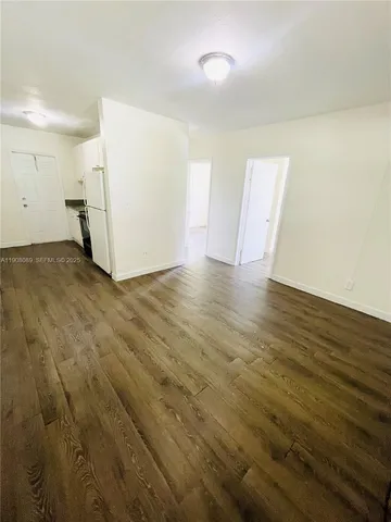 an empty room with wooden floor and white walls