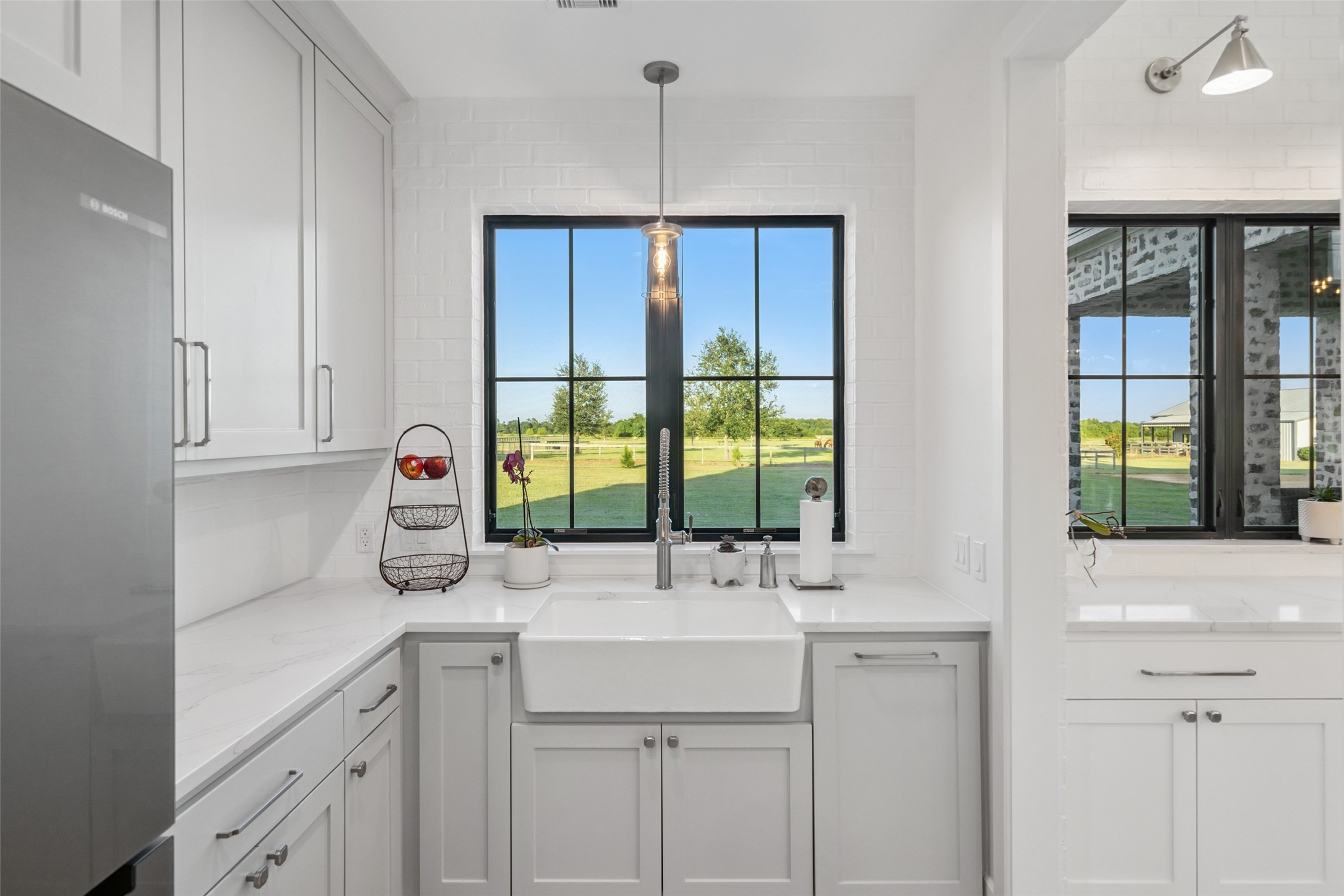 24118 Margerstadt Road Hockley, TX 77447 - Photo 11 of 50 The oversized farmhouse sink, quartz counters, and a Bosch fridge elevate this butler’s pantry, perfectly positioned for serving and prep with peaceful pasture views.
