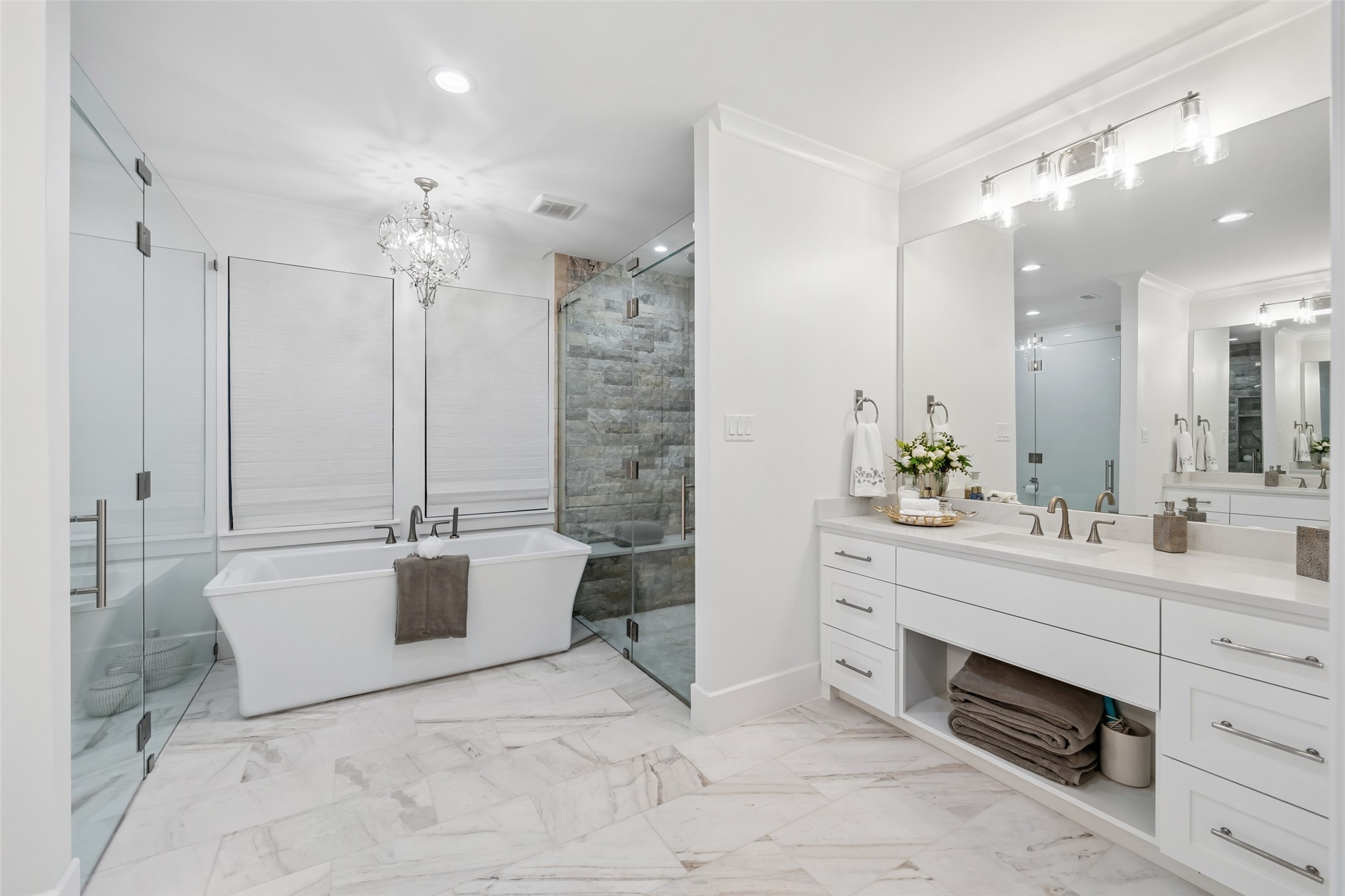 24118 Margerstadt Road Hockley, TX 77447 - Photo 19 of 50 This spa-style primary bath includes a soaking tub, dual vanities, and a walk-in glass shower, accented by soft lighting and natural stone textures.