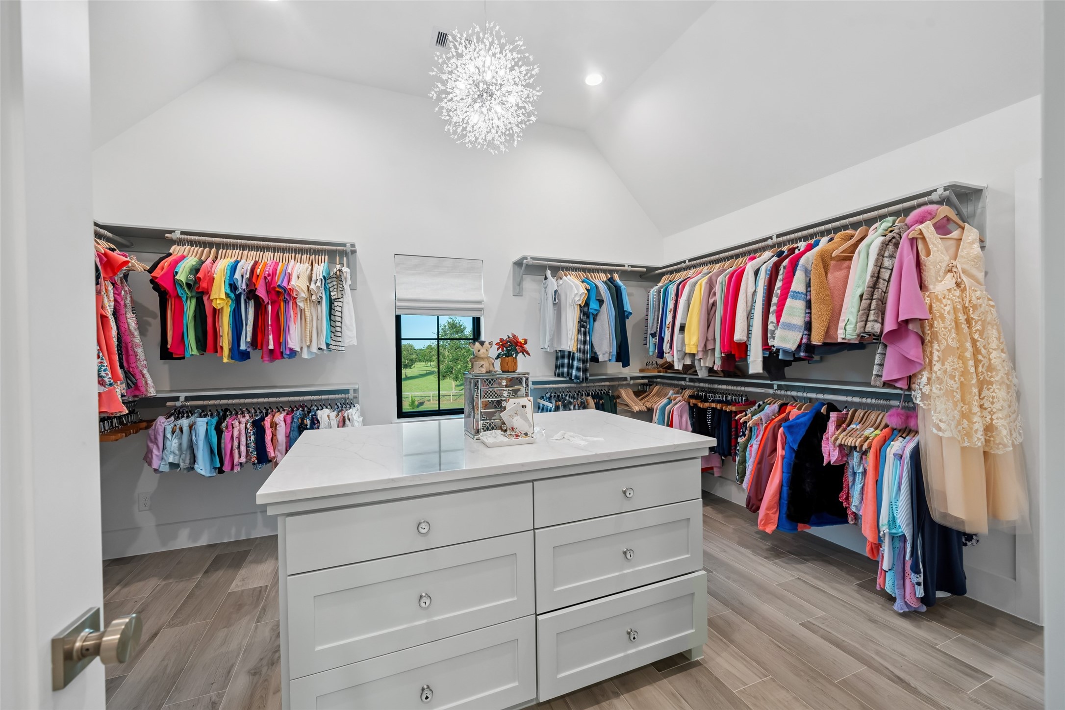24118 Margerstadt Road Hockley, TX 77447 - Photo 33 of 50 Custom walk-in closet with a built-in island, elevated ceiling, and window views—designed for storage and presentation.