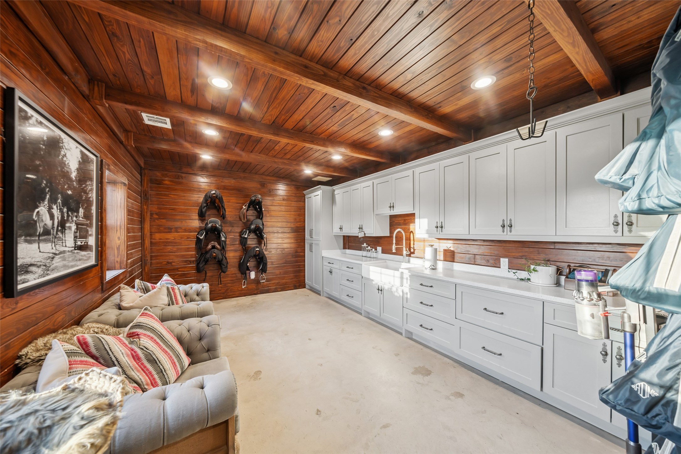 24118 Margerstadt Road Hockley, TX 77447 - Photo 40 of 50 Rich wood paneling and built-in cabinetry define the air-conditioned tack room, complete with sink, fridge, and 220V outlets—designed with conversion potential in mind.