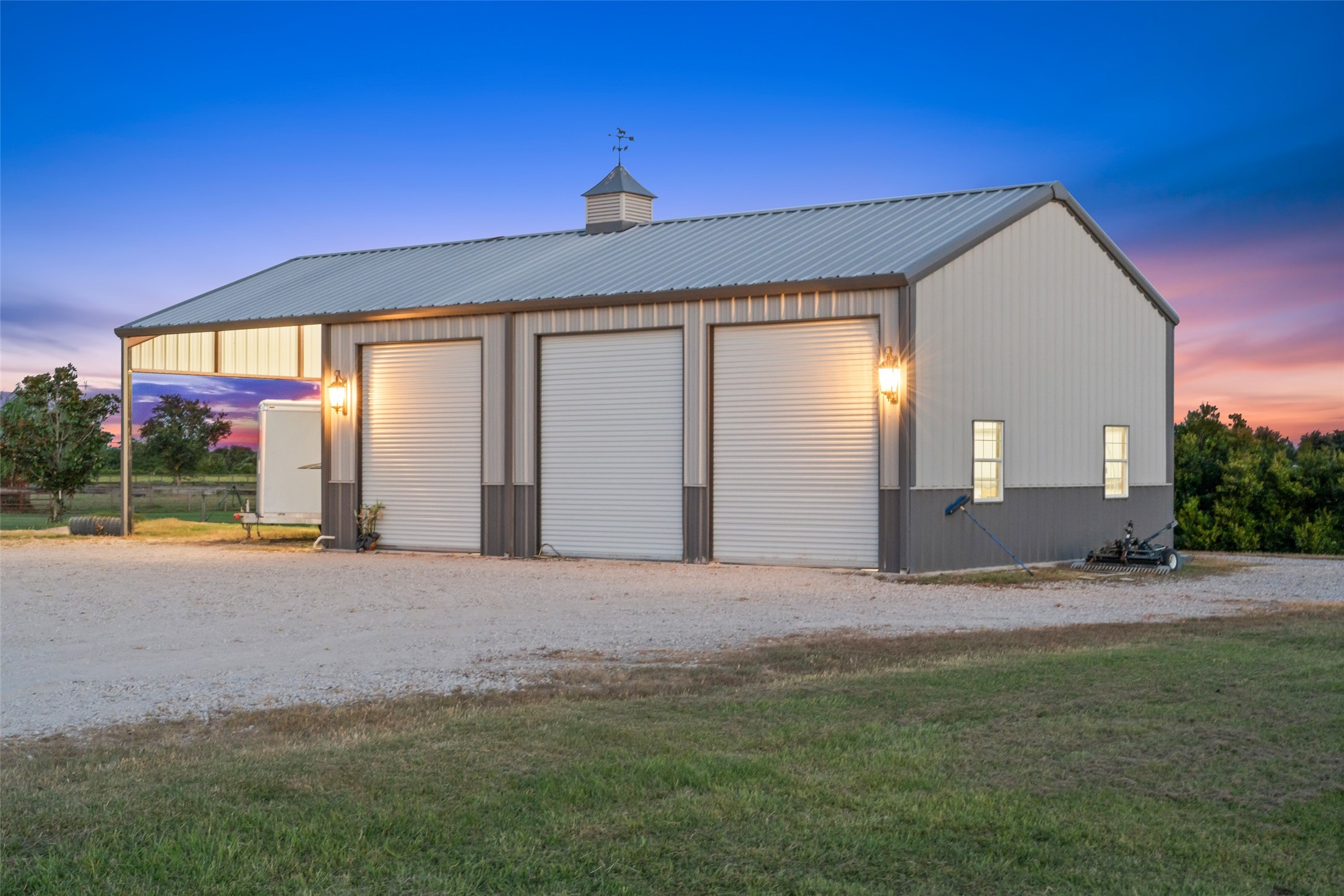 24118 Margerstadt Road Hockley, TX 77447 - Photo 46 of 50 Evening lighting highlights the fully insulated workshop, complete with power, water, and a half bath—ready for a range of uses.