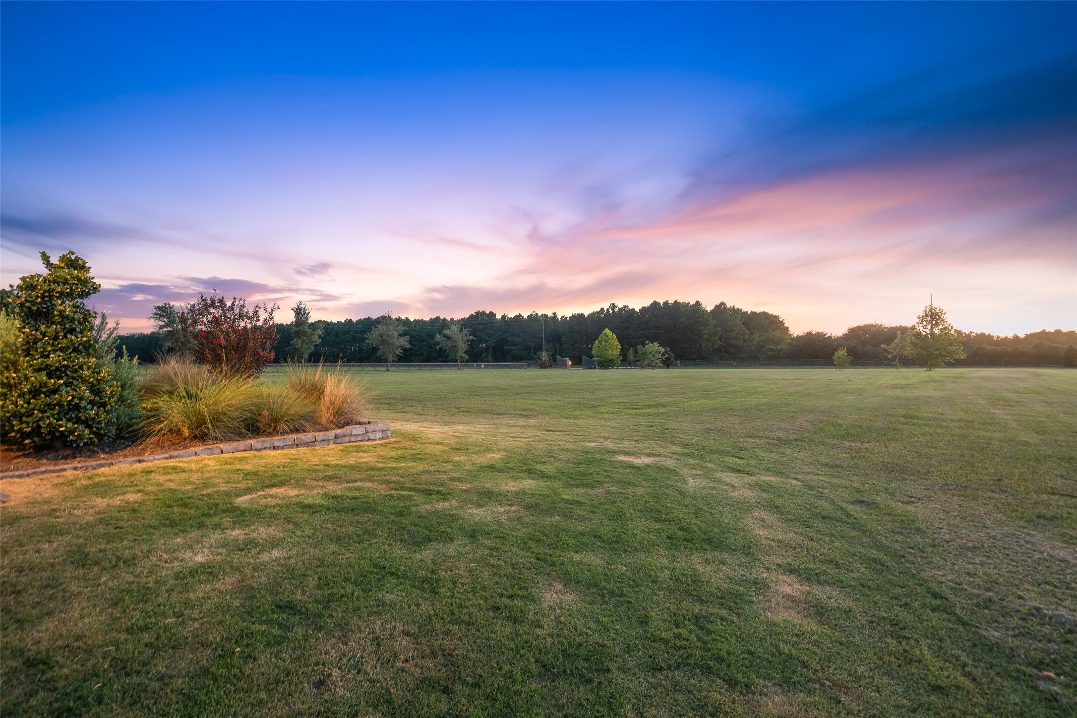 24118 Margerstadt Road Hockley, TX 77447 - Photo 50 of 50 Expansive manicured grounds stretch toward the treeline, offering open views and endless potential—captivating for a serene finish to the day.