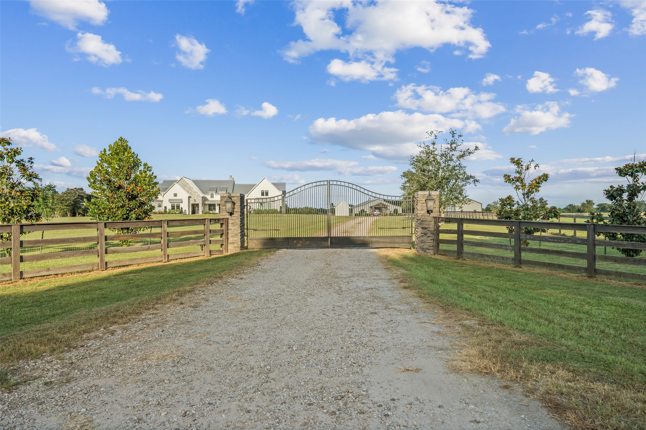 24118 Margerstadt Road Hockley, TX 77447 - Photo 7 of 50 A custom-designed electric gate with stone columns and double gate openers sets the tone for privacy, security, and elevated rural living.