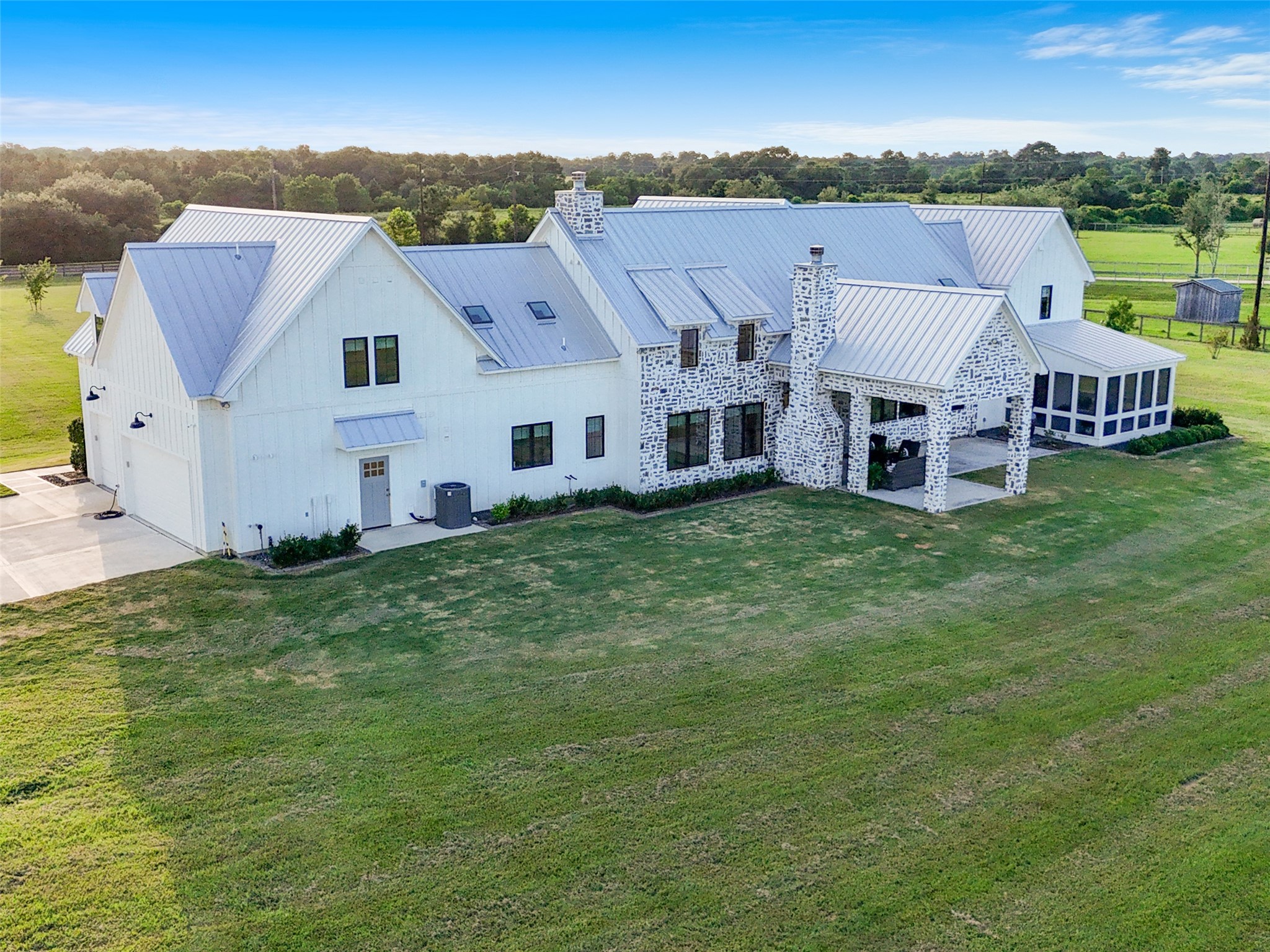 24118 Margerstadt Road Hockley, TX 77447 - Photo 9 of 50 Rear elevation reveals the covered patio with wood-burning fireplace, full chimney, and adjacent screened porch—each thoughtfully positioned to overlook the surrounding acreage.