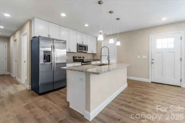 a kitchen with stainless steel appliances a refrigerator sink and microwave