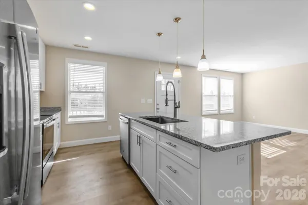 a kitchen with stainless steel appliances granite countertop a sink a stove and a refrigerator