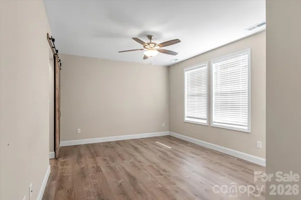 a view of an empty room with a window and a fan