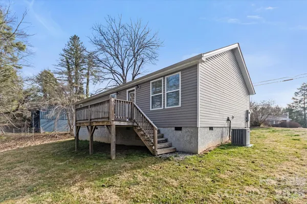 a view of a house with a yard chairs and wooden fence