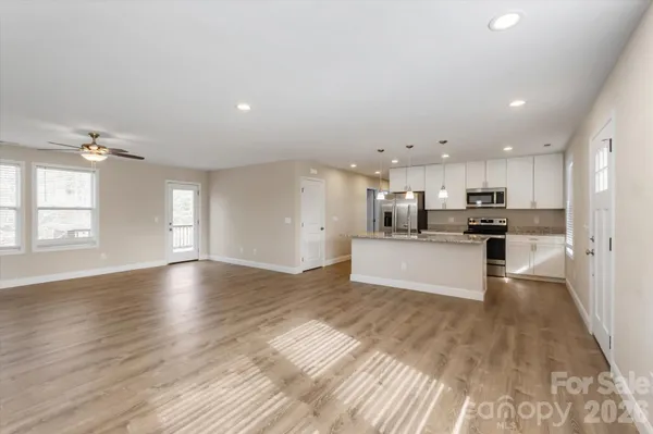 a view of kitchen with kitchen island stainless steel appliances refrigerator stove microwave and cabinets