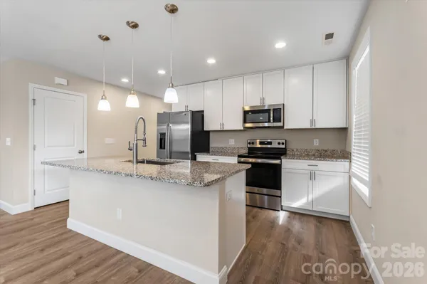 a kitchen with kitchen island granite countertop stainless steel appliances and sink
