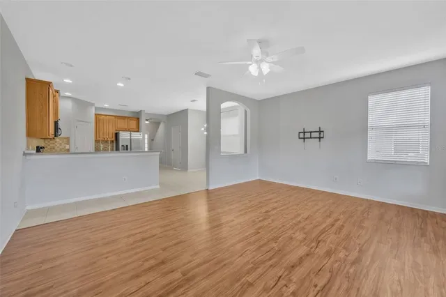 a view of a kitchen with wooden floor and a ceiling fan