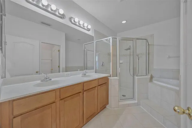 a spacious bathroom with a granite countertop sink a mirror and a shower