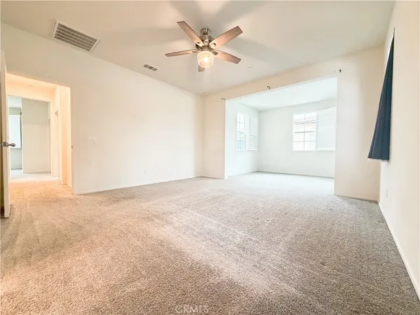 a view of a livingroom with a ceiling fan and window