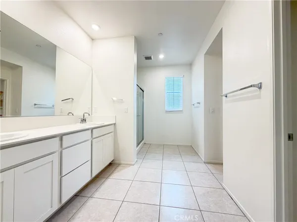 a spacious bathroom with a mirror sink and shower
