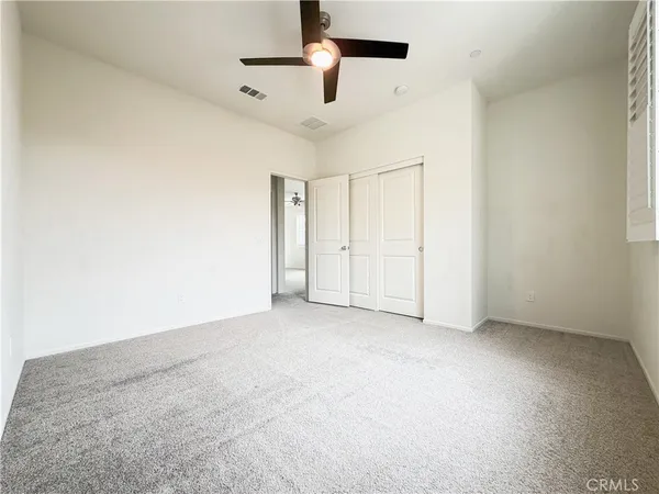 an empty room with chandelier fan
