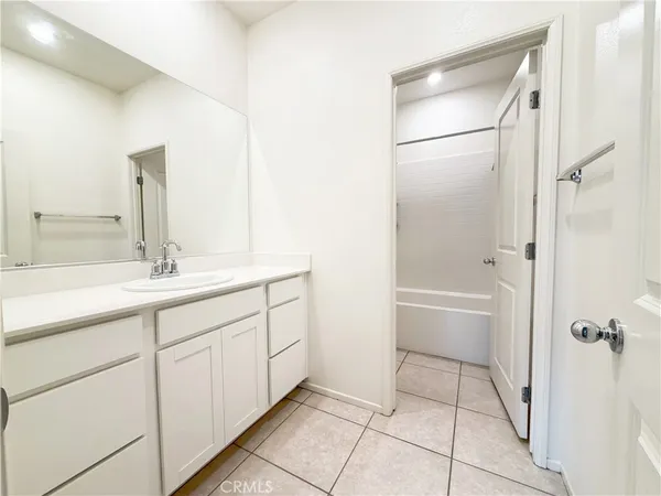 a bathroom with a double vanity sink a mirror and a bathtub