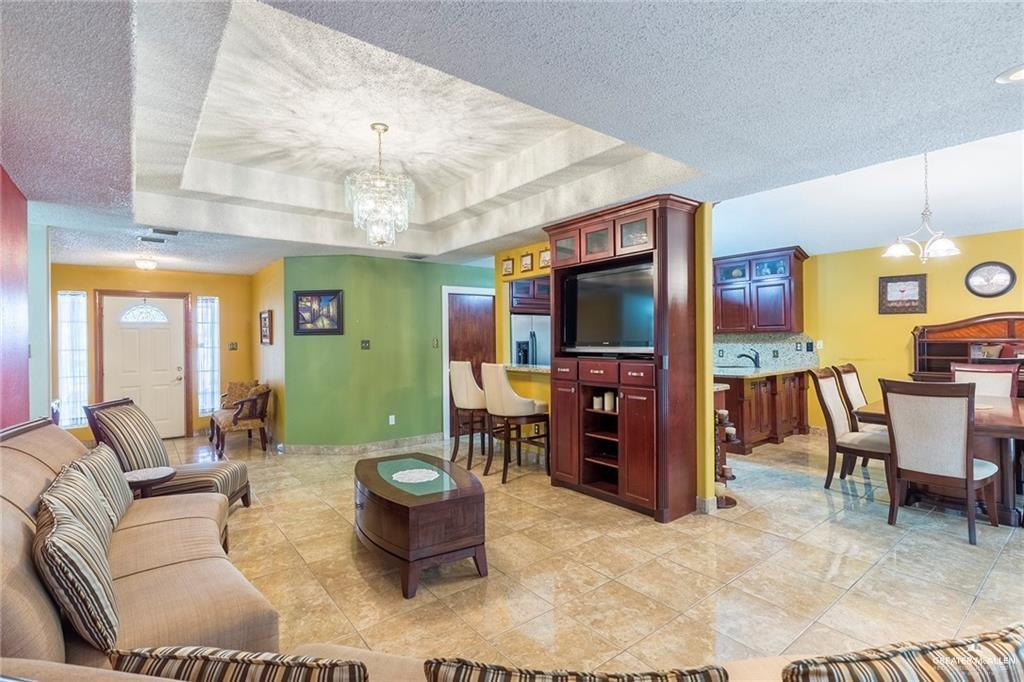 1801 Crown Pointe Boulevard Mission, TX 78572 - Photo 2 of 19 a living room with furniture a dining table and a flat screen tv