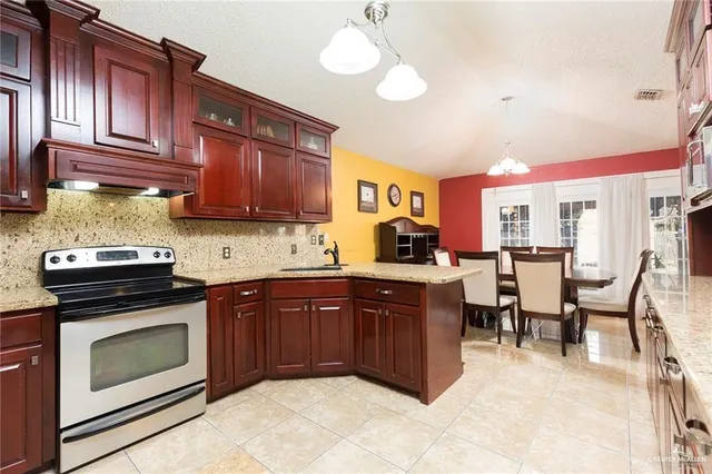a kitchen with stainless steel appliances granite countertop wooden cabinets a stove top oven a sink and dishwasher
