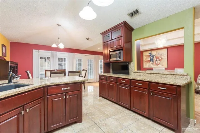 a kitchen with granite countertop a sink and cabinets