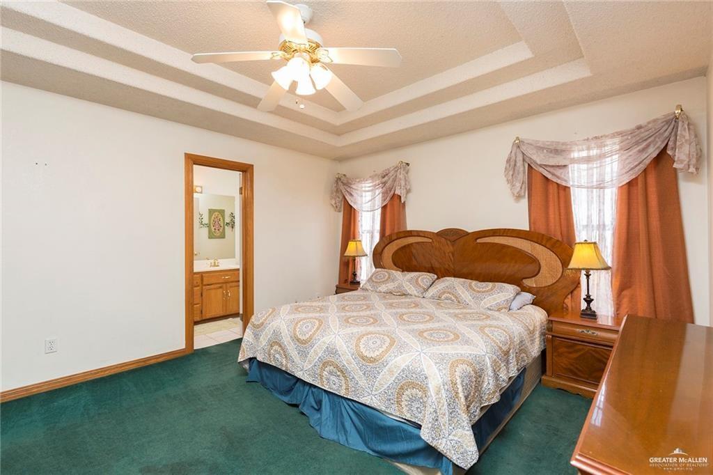 1801 Crown Pointe Boulevard Mission, TX 78572 - Photo 9 of 19 a bedroom with a bed and a chandelier