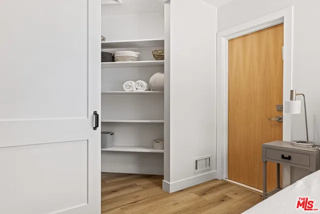 a view of a closet with wooden floor